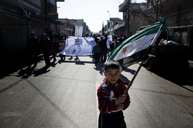 A young boy carries the Syrian-rebel adopted flag during an anti-regime demonstration in the Syrian village of al-Qsair, not far from Homs.
