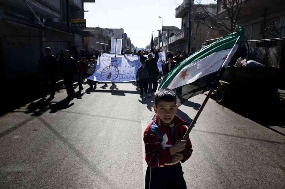 A young boy carries the Syrian-rebel adopted flag during an anti-regime demonstration in the Syrian village of al-Qsair, not far from Homs.