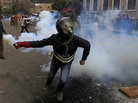 In Cairo earlier today, a masked Egyptian protester prepared to throw back a tear gas canister fired by security forces. In Cairo earlier today, a masked Egyptian protester prepared to throw back a tear gas canister fired by security forces.