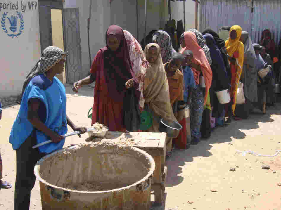 Displaced families line up to receive food rations at a feeding center in Somalia.