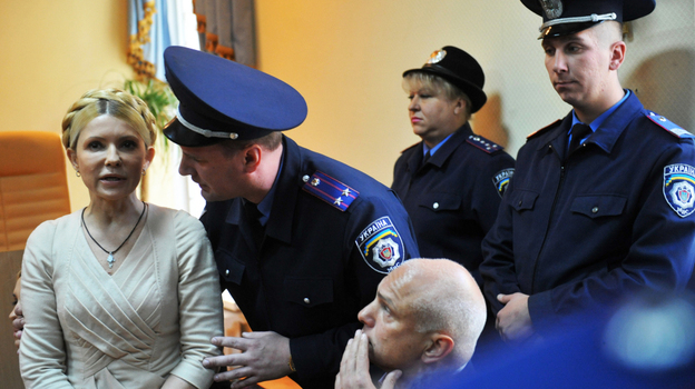 A police officer speaks to Ukraine's former prime minster, Yulia Tymoshenko, after she was convicted of abuse of power charges in a court in Kiev on Oct. 11, 2011. She is now serving a seven-year term, but her supporters say the charges against her were politically motivated. A police officer speaks to Ukraine's former prime minster, Yulia Tymoshenko, after she was convicted of abuse of power charges in a court in Kiev on Oct. 11, 2011. She is now serving a seven-year term, but her supporters say the charges against her were politically motivated.