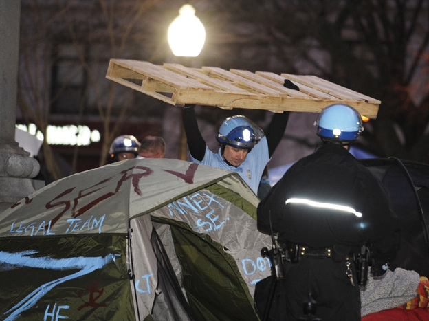 A U.S. Park Police officer removes a wooden structure from an Occupy D.C. protester's tent at McPherson Square in Washington, D.C., on Saturday.