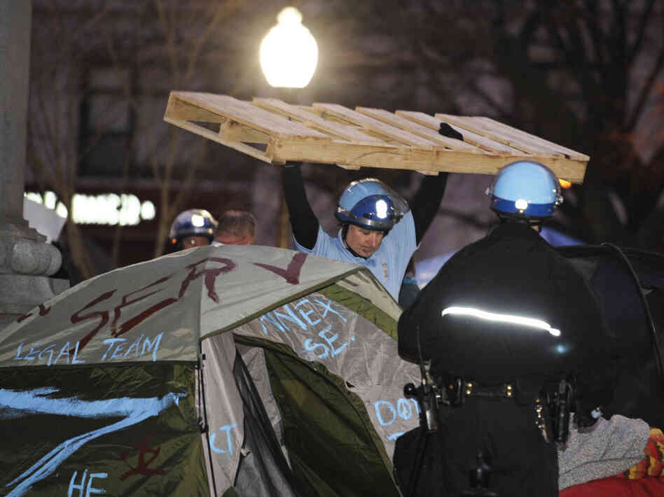 A U.S. Park Police officer removes a wooden structure from an Occupy D.C. protester's tent at McPherson Square in Washington, D.C., on Saturday.