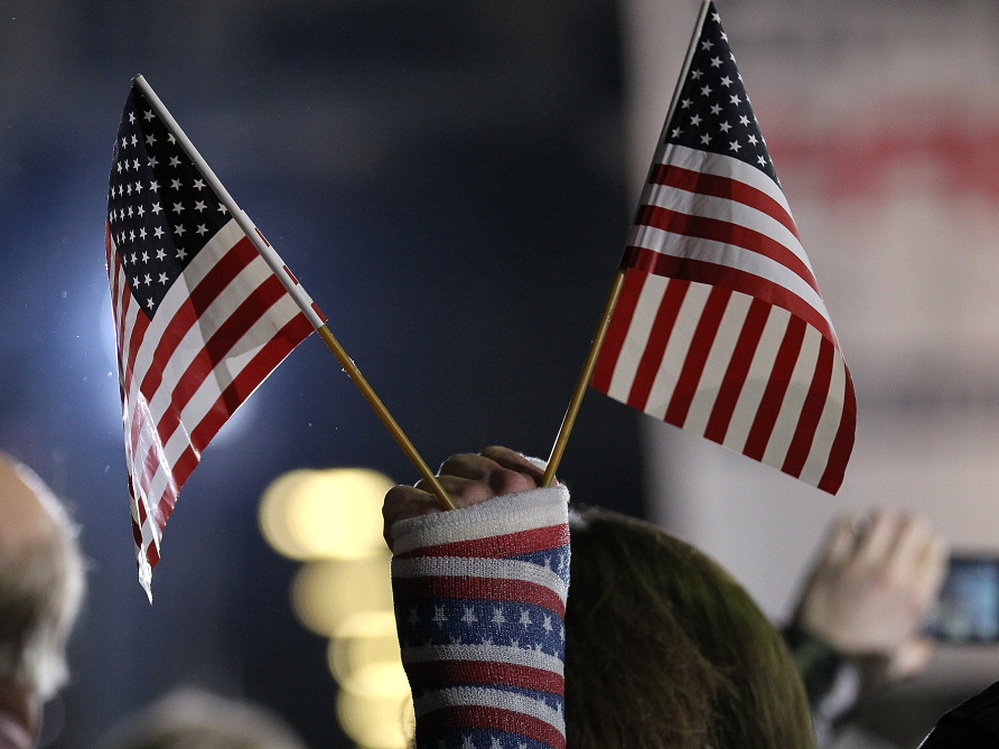 An attendee holds American flags during a rally Saturday in Colorado Springs, Colo. The rally was for Republican Mitt Romney, but a new study says the number of newly declared independents is outpacing new registration for either Republicans or Democrats in the state. 