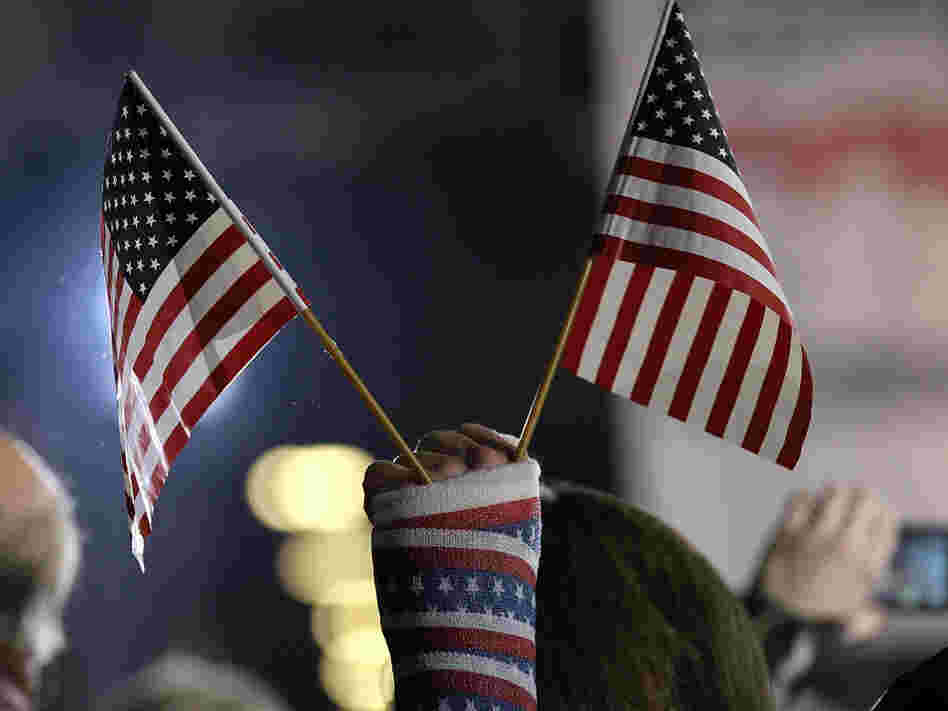 An attendee holds American flags during a rally Saturday in Colorado Springs, Colo. The rally was for Republican Mitt Romney, but a new study says the number of newly declared independents is outpacing new registration for either Republicans or Democrats in the state. 