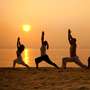 Five people on a beach stand in the warrior pose. Five people on a beach stand in the warrior pose.