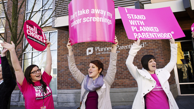 Aurora Jewell, Mandi Moshay and Kirsten Dees (left to right) hold up signs following a press conference by U.S. Sen. Patty Murray (D-WA) outside at a Planned Parenthood Clinic in Seattle, on Feb. 3.
