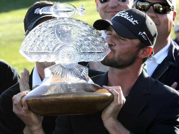 Tournament winner Kyle Stanley kisses the championship trophy after the final round of the Phoenix Open golf tournament on Sunday.