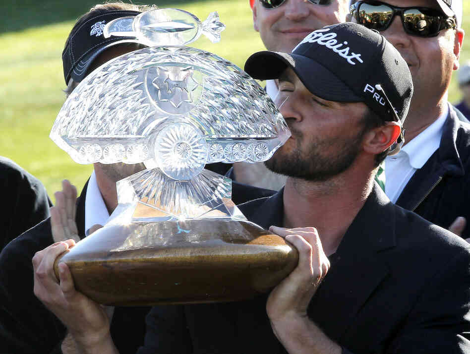 Tournament winner Kyle Stanley kisses the championship trophy after the final round of the Phoenix Open golf tournament on Sunday.
