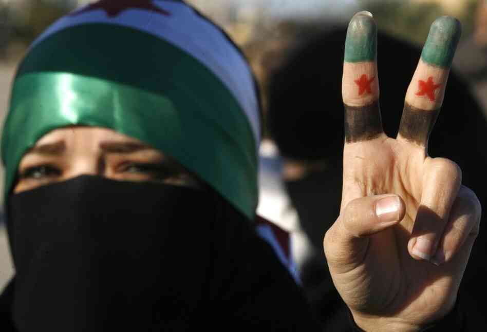 A woman flashes the V for 'victory' sign with her fingers painted in the colors of the former Syrian flag during a protest against the Syrian regime outside Damascus' embassy in Kuwait City on Feb. 5, 2012. A woman flashes the V for 'victory' sign with her fingers painted in the colors of the former Syrian flag during a protest against the Syrian regime outside Damascus' embassy in Kuwait City on Feb. 5, 2012.