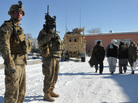 Afghan men walk past American soldiers in Ghazni province on Thursday. U.S. and Afghan officials are in talks that will determine how many American troops stay in Afghanistan after the NATO mission ends in 2014. Afghan men walk past American soldiers in Ghazni province on Thursday. U.S. and Afghan officials are in talks that will determine how many American troops stay in Afghanistan after the NATO mission ends in 2014.