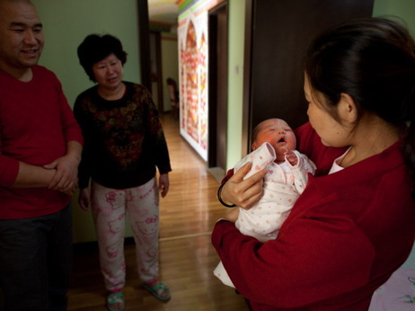 Yu Qiuyan (right) held her newborn baby girl Li Muhua, as father Li Wanhong (left) and a relative stood by in Beijing on January 26. Yu Qiuyan (right) held her newborn baby girl Li Muhua, as father Li Wanhong (left) and a relative stood by in Beijing on January 26.