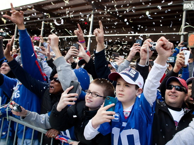 As the paper falls, New York Giants fans cheer during today's parade in Manhattan.