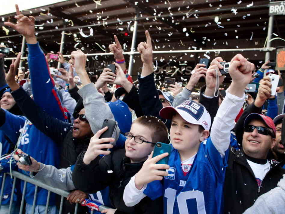 As the paper falls, New York Giants fans cheer during today's parade in Manhattan.