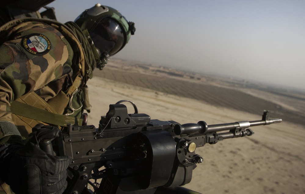 A French gunner mans a machine gun in a Puma helicopter as it flies over Afghanistan. French President Nicolas Sarkozy recently ordered the withdrawal of all French troops from the country a year ahead of schedule.