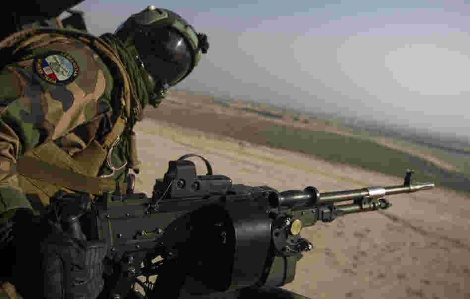 A French gunner mans a machine gun in a Puma helicopter as it flies over Afghanistan. French President Nicolas Sarkozy recently ordered the withdrawal of all French troops from the country a year ahead of schedule.