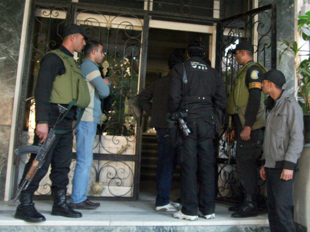 Members of the Egyptian military stand guard as officials raid the offices of a nongovernmental organization in Cairo. Egyptian investigating judges referred international NGO workers to trial for allegedly being involved in banned activities and illegally receiving foreign funds, security officials said. 
