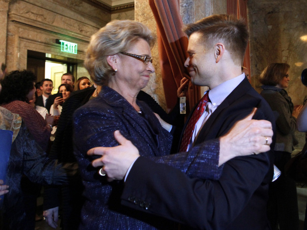 Gov. Chris Gregoire, left, embraces Rep. Jamie Pedersen, D-Seattle, after the Washington state House voted Wednesday to legalize gay marriage.
