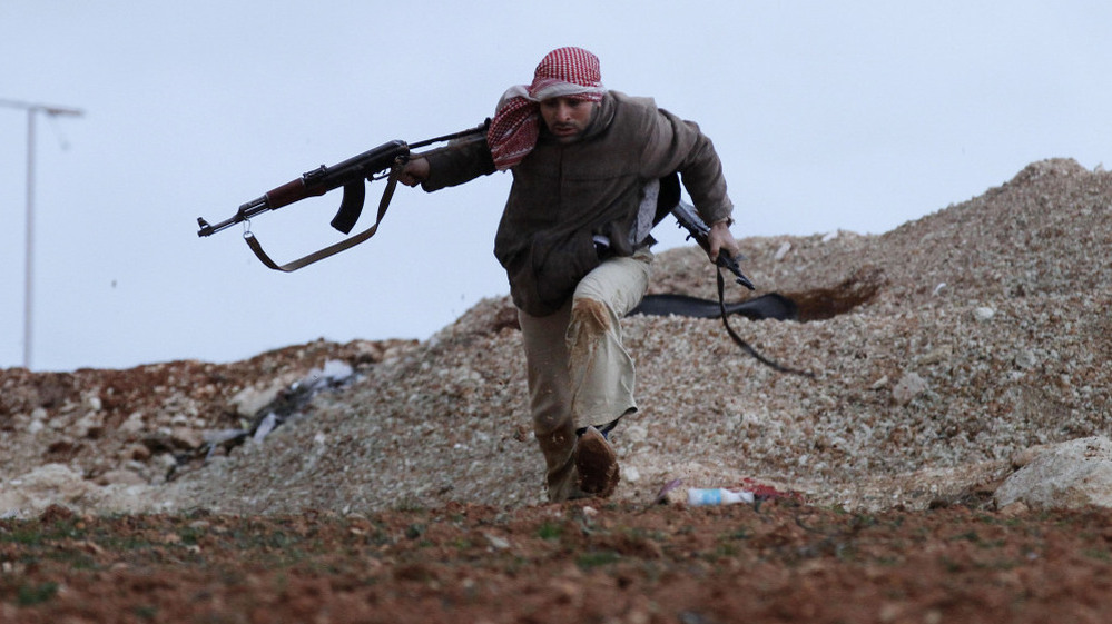 A Syrian rebel runs for cover during an exchange of fire with army troops in Idlib, Syria.