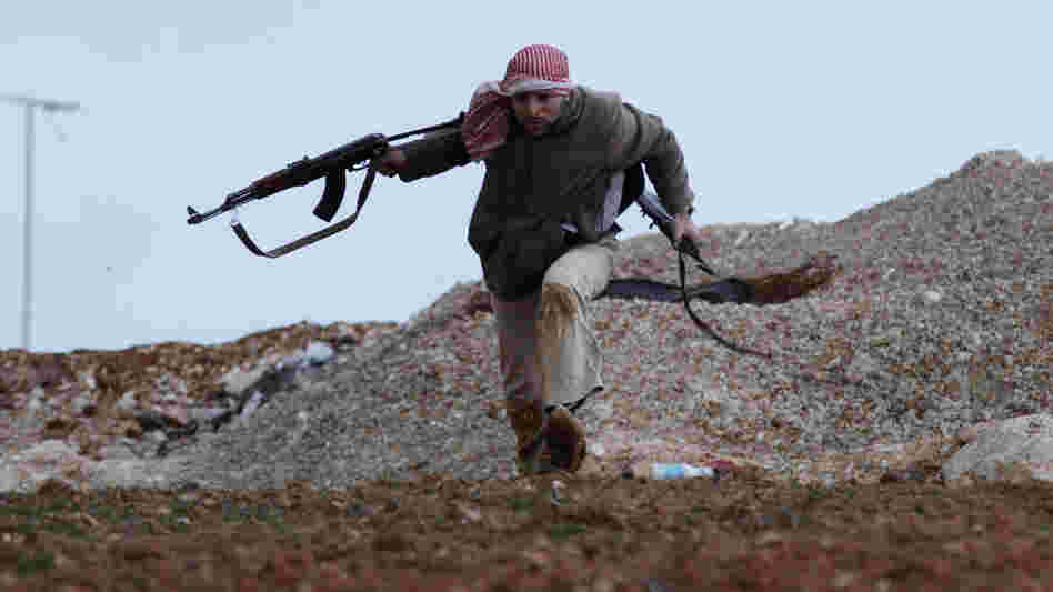 A Syrian rebel runs for cover during an exchange of fire with army troops in Idlib, Syria.