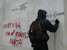 Protesters write on the wall of the National Bank of Greece during a demonstration involving thousands in Athens on Friday. Protesters write on the wall of the National Bank of Greece during a demonstration involving thousands in Athens on Friday.