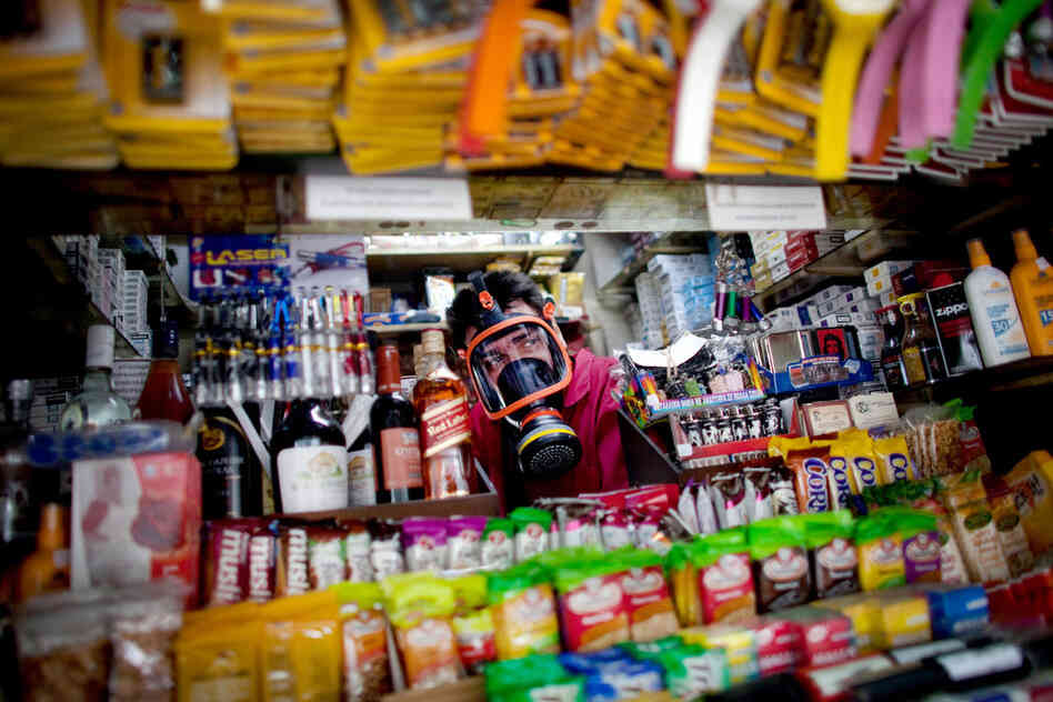 A kiosk owner wears a gas mask during anti-austerity protests outside parliament in Athens last June.