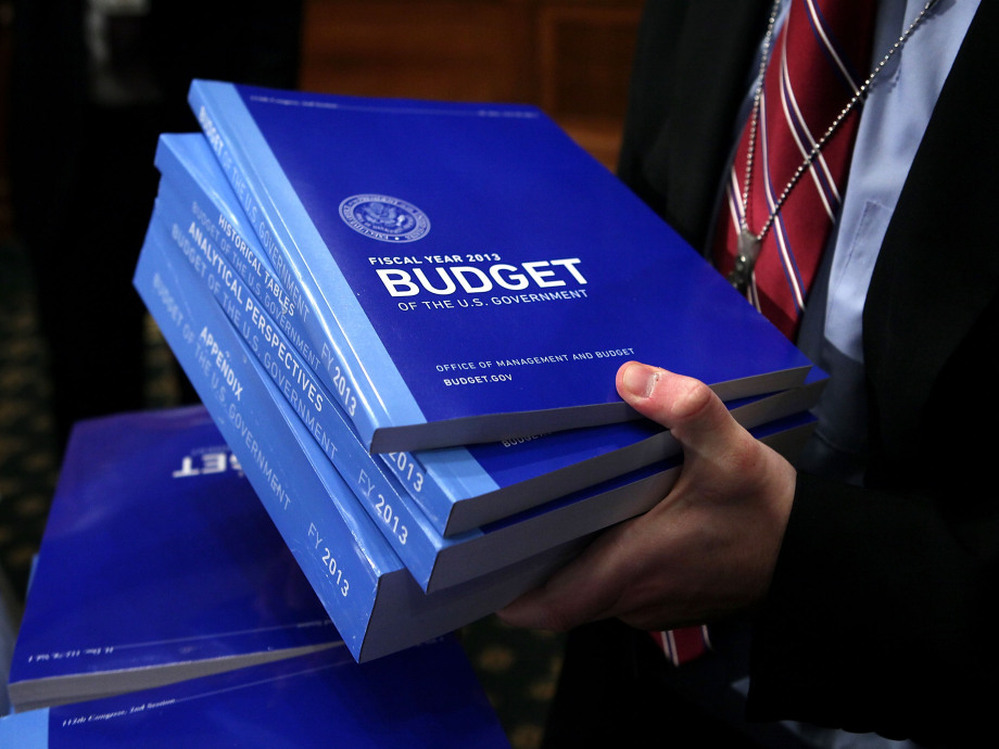 A congressional staffer collects copies of the president's 2013 budget request from the Senate Budget Committee on Monday in Washington, D.C.