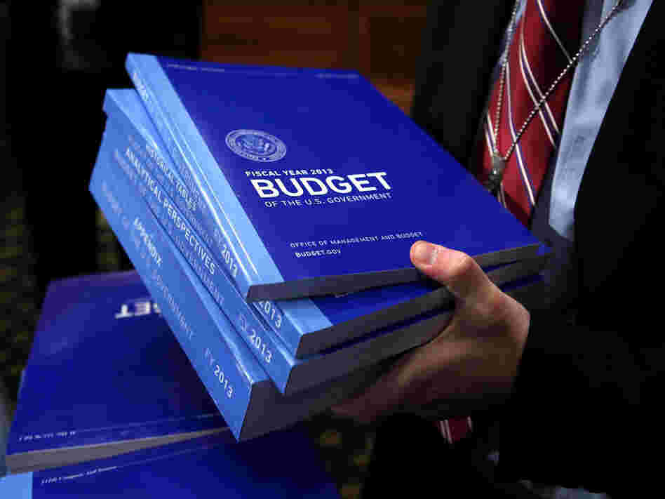 A congressional staffer collects copies of the president's 2013 budget request from the Senate Budget Committee on Monday in Washington, D.C.