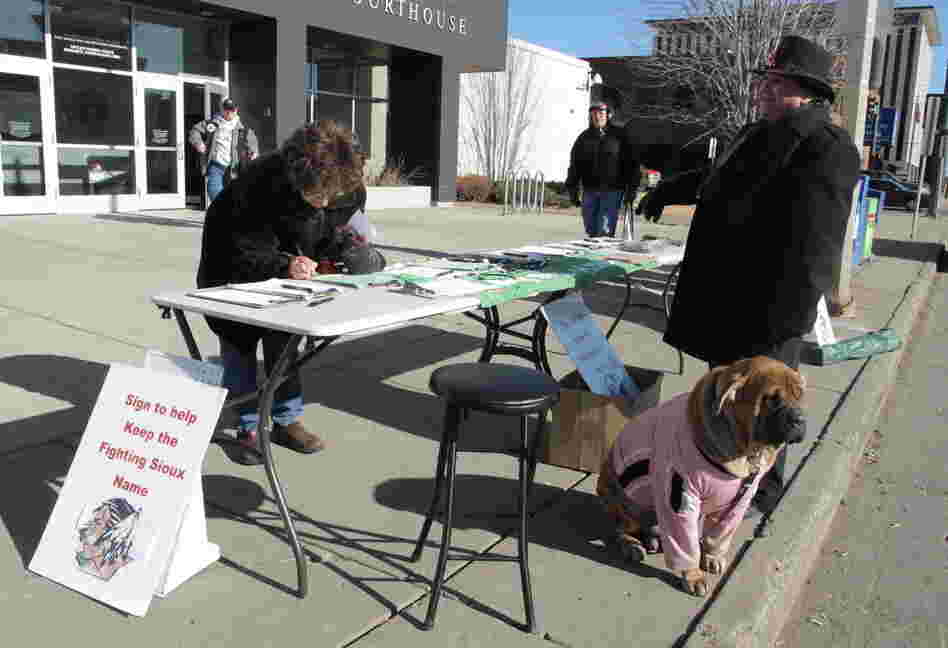 Charles Tuttle, a backer of the University of North Dakota's Fighting Sioux nickname, watches as a woman signs petitions supporting the nickname on Tuesday, Feb. 7.