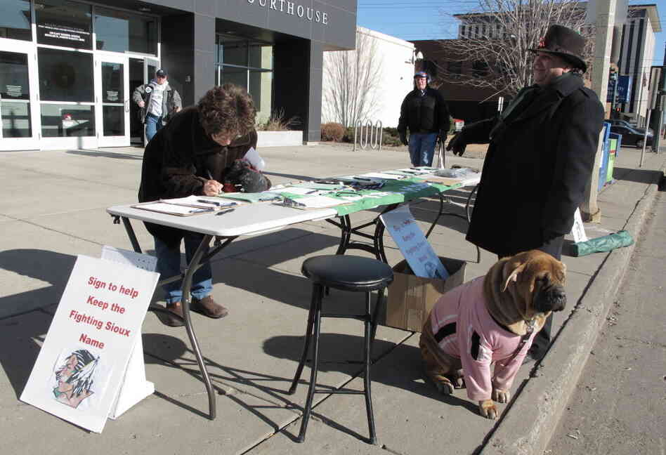 Charles Tuttle, a backer of the University of North Dakota's Fighting Sioux nickname, watches as a woman signs petitions supporting the nickname on Tuesday, Feb. 7.