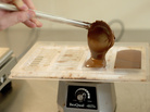 Ben Rasmussen pours tempered chocolate into a tray, where it will harden into a finished bar. Ben Rasmussen pours tempered chocolate into a tray, where it will harden into a finished bar.