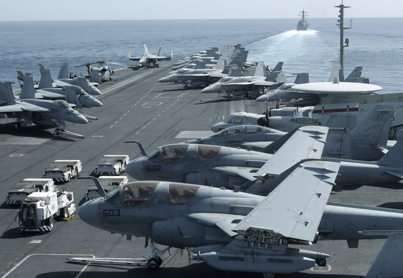 The USS Abraham Lincoln sailed from the Persian Gulf through the Strait of Hormuz on Tuesday. This photo was taken from the bridge of the aircraft carrier and shows U.S. aircraft parked on its flight deck. In the background, a U.S. destroyer patrols.