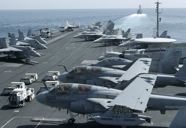 The USS Abraham Lincoln sailed from the Persian Gulf through the Strait of Hormuz on Tuesday. This photo was taken from the bridge of the aircraft carrier and shows U.S. aircraft parked on its flight deck. In the background, a U.S. destroyer patrols. The USS Abraham Lincoln sailed from the Persian Gulf through the Strait of Hormuz on Tuesday. This photo was taken from the bridge of the aircraft carrier and shows U.S. aircraft parked on its flight deck. In the background, a U.S. destroyer patrols.
