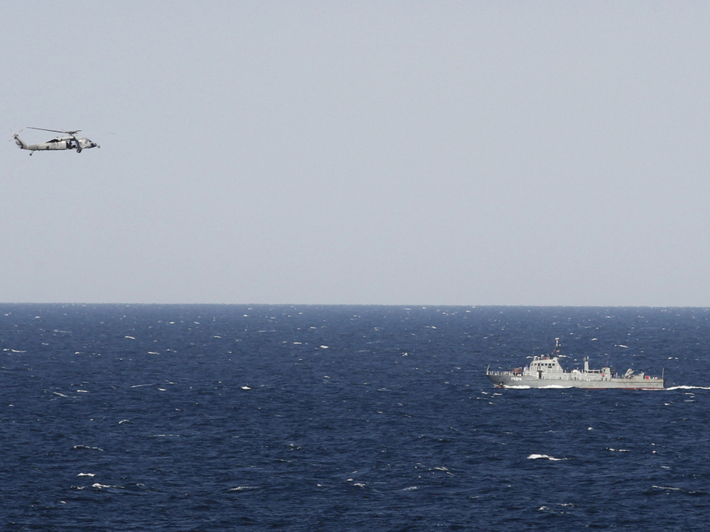 A helicopter from the aircraft carrier USS Abraham Lincoln hovers over an Iranian patrol ship during a transit through the Strait of Hormuz on Tuesday.