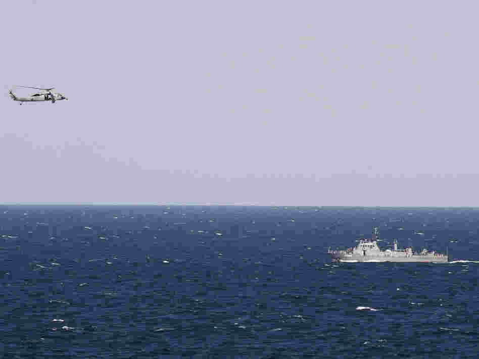 A helicopter from the aircraft carrier USS Abraham Lincoln hovers over an Iranian patrol ship during a transit through the Strait of Hormuz on Tuesday.
