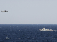 A helicopter from the aircraft carrier USS Abraham Lincoln hovers over an Iranian patrol ship during a transit through the Strait of Hormuz on Tuesday.