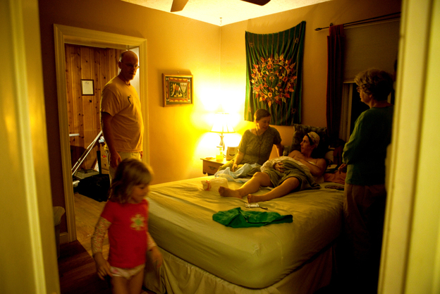 Midwife Erin Fulham, left, takes care of Shannon Earle and her new baby Kiera. Daughter Riana, the father, Patrick, and his mother, Ann Earle, look on at the family's home in Takoma Park, Md., in 2011.