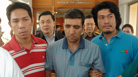 Thai immigration officers escort detained Iranian Mohammad Kharzei, center, at the immigration headquarters in Bangkok on Thursday. Thai immigration officers escort detained Iranian Mohammad Kharzei, center, at the immigration headquarters in Bangkok on Thursday.
