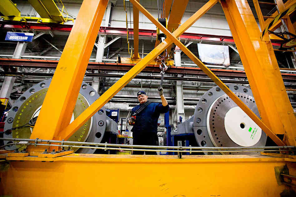 Angel Gonzales operates a crane to assemble a gear box for a wind turbine. The heavy-lift cranes hoist pieces weighing up to 70 tons.