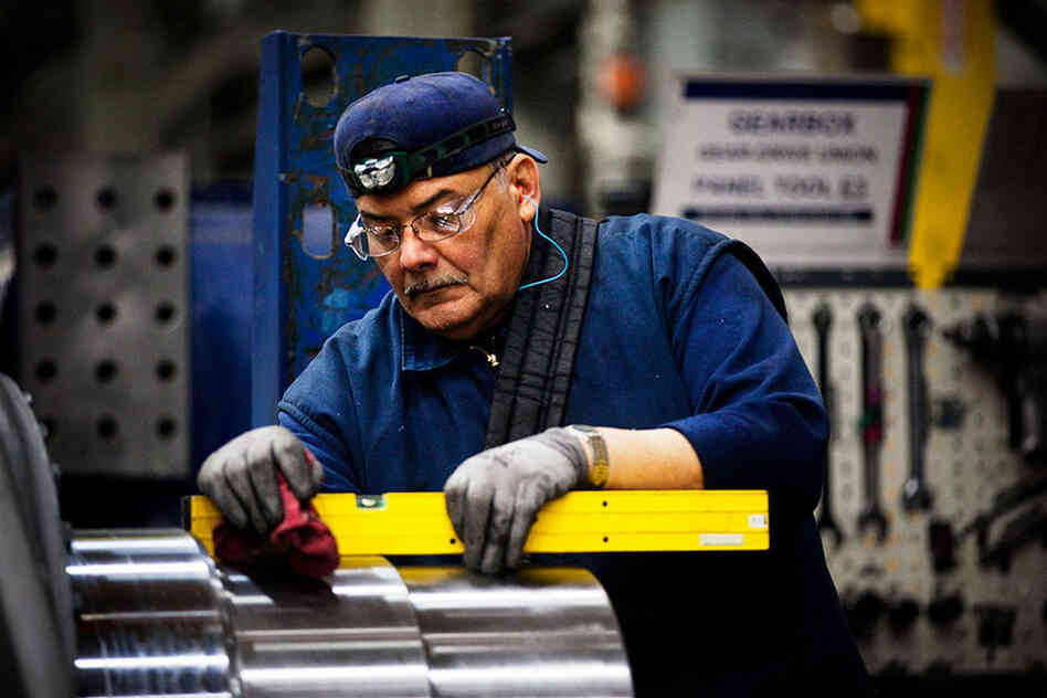 Angel Gonzales assembles a main shaft of a wind turbine. Tens of thousands of jobs depend on a federal tax credit meant to help keep wind power competitive with other forms of electricity.