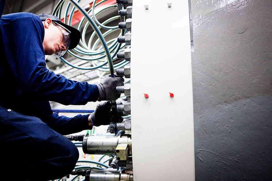 Joseph Wright tightens bolts on the hub of a wind turbine. Sixty percent of the components used in wind turbines are manufactured in the U.S., according to the American Wind Energy Association.