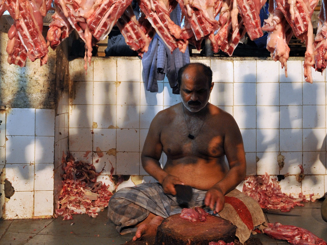 An Indian butcher chops meat at a mutton market in Mumbai. Indians are consuming more meat than ever before, despite a tradition of vegetarianism.