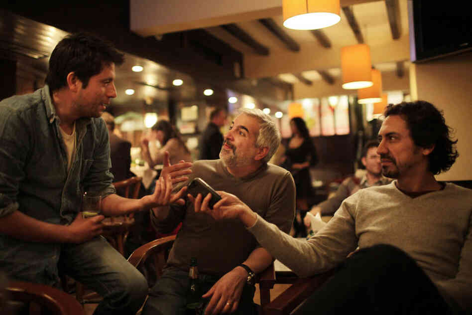 Shadid (center) shares a story with colleagues Moises Saman (left) and Kareem Fahim (right) in a  Cairo restaurant after the fall of Egyptian President Hosni Mubarak last year. 