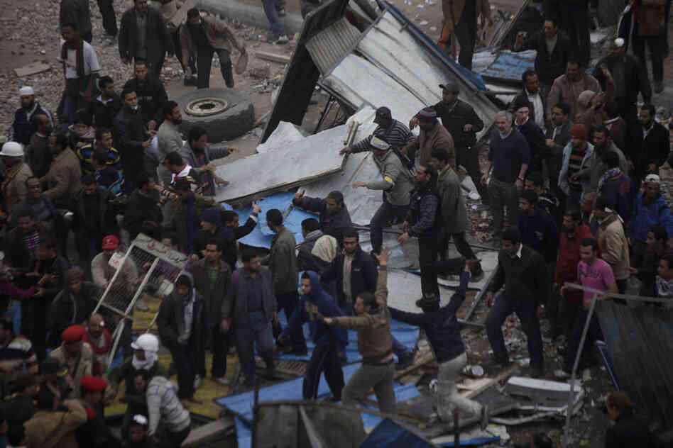 Shadid (in the top right part of this photo) follows Egyptian protesters during clashes between pro-Mubarak supporters and anti-government protesters in Tahrir Square, 2011. 