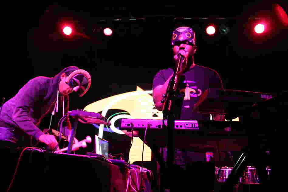 The singer Sampha (at right, in mask T-shirt) performs with SBTRKT in concert. During performances, the producer wears a mask that covers just half of his face. 