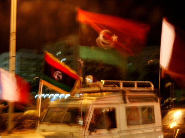 Libyan flags fly above the cars lining the streets of Benghazi.