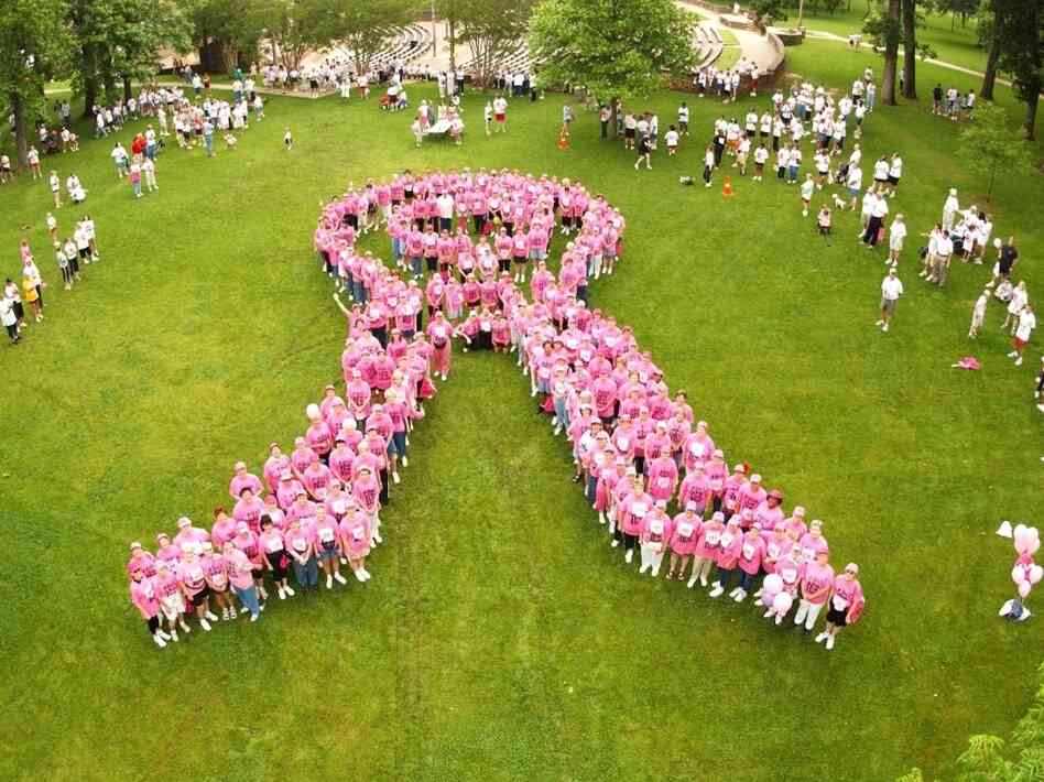  Breast cancer survivors stand to form the shape of a pink ribbon at a Susan G. Komen Foundation charity race in Tyler, Texas, in 2004.