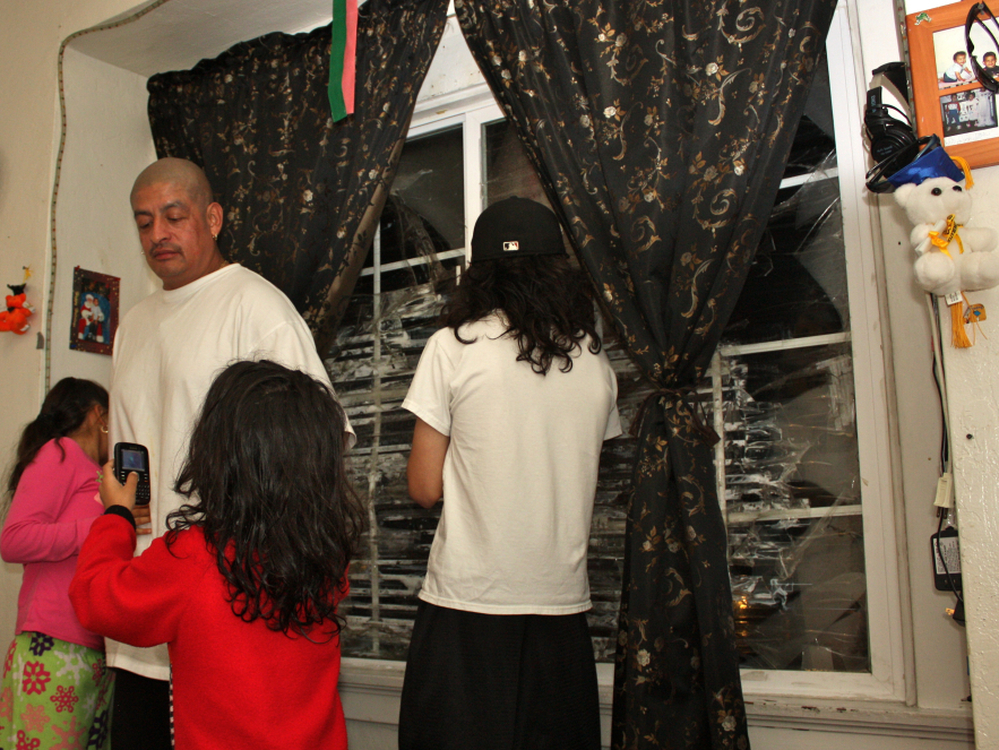  Pedro Jimenez and three of his kids, in the living room of their Oakland, Calif., apartment. JPMorgan Chase hasn't hired a management company to fix the shattered window panes or make other repairs. 