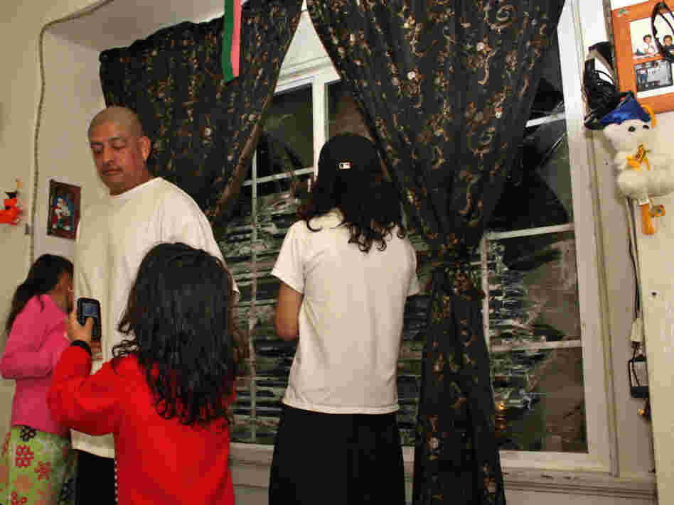  Pedro Jimenez and three of his kids, in the living room of their Oakland, Calif., apartment. JPMorgan Chase hasn't hired a management company to fix the shattered window panes or make other repairs. 