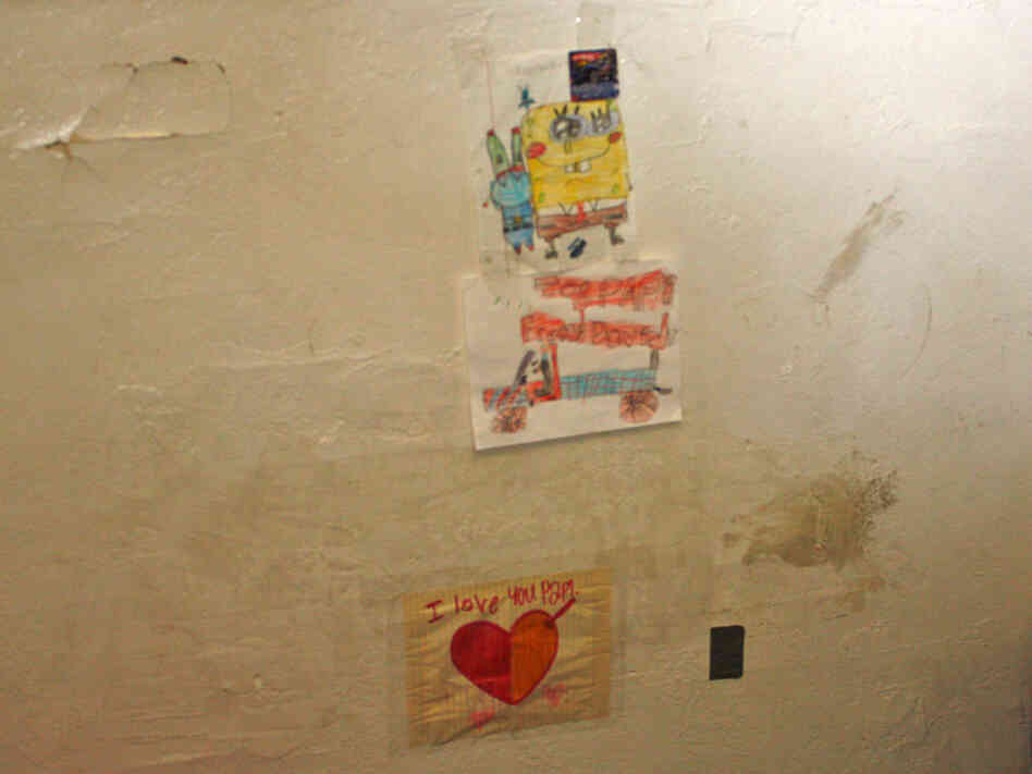 David Jimenez, 7, patches up holes in his East Oakland, Calif., apartment. The bottom sticky note says, "I love you Papi." 